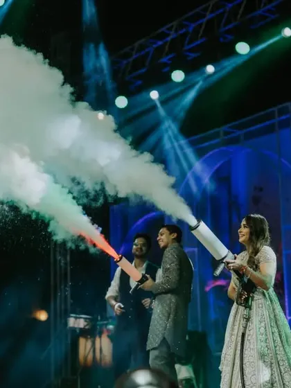 Let the party begin! The bride and groom kick off the celebration on stage, using CO2 guns to energize the crowd. It's a high-impact moment that signals a night of unforgettable fun.