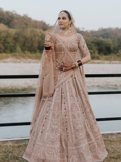 The bride against a scenic backdrop. The pastel lehenga and minimalist makeup create a look that is both modern and romantic.