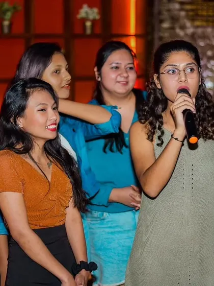 A group of friends waiting for their turn and supporting the current singer. The community vibe at my events is just as important as the music.