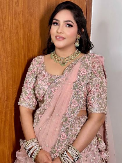 A beautiful and soft sagan makeup look. The focus is on flawless skin and rosy tones, which look stunning with her pastel pink embroidered lehenga.