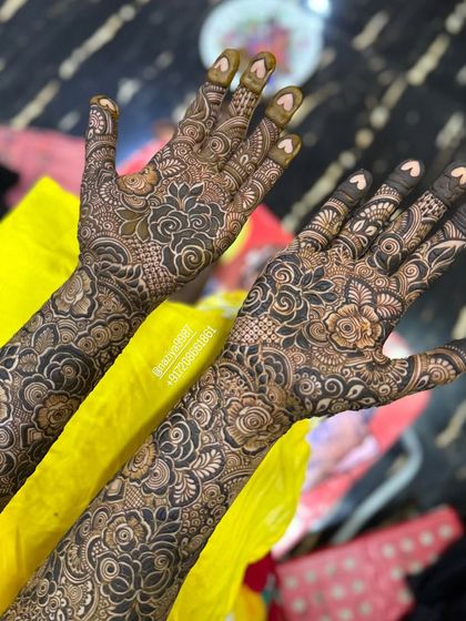 A close-up of the palms for this bridal design, featuring tiny hearts on the fingertips.