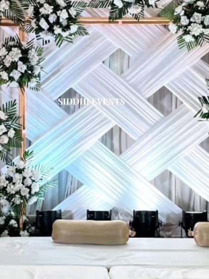 A close-up of the woven white fabric backdrop, framed by a square of pristine white flowers, creating a clean, modern, and textured look.