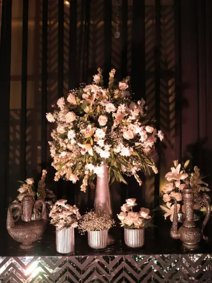 A stunning floral display on a mirrored table. The combination of soft pink and white flowers against the dark, moody backdrop of the Sangeet added a touch of romance to the glamorous decor.