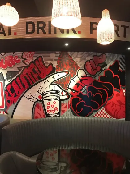 This section of our mural for the Downtown Dive restobar features pop-art hands and bold graffiti lettering. The art creates a lively, urban atmosphere perfect for a social space.