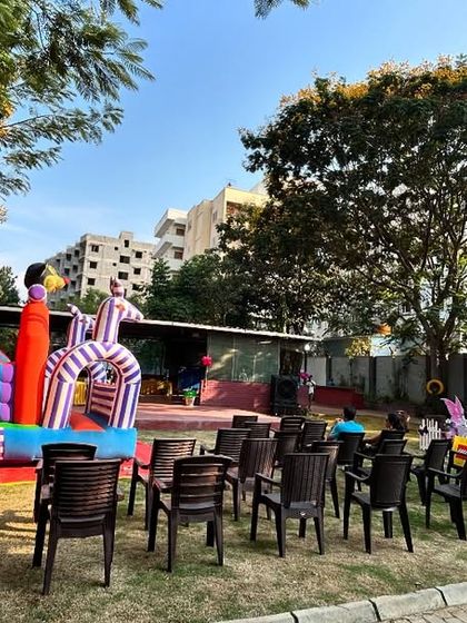 A wide shot of the outdoor venue, showing the butterfly decoration area and the large bouncy castle for kids.