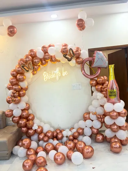 This chic bridal shower decor is perfect for creating those Instagram-worthy moments. I used a popular rose gold and white color palette to build a full balloon arch, adding fun elements like a diamond ring and champagne bottle foil balloon, all centered around a 'Bride to be' neon sign.