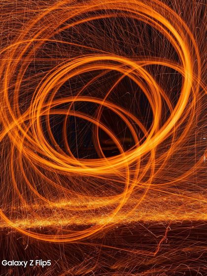 An abstract spiral of light created with steel wool and the Samsung Galaxy Z Flip 5. This image focuses on the pure artistry of light painting, producing a mesmerizing and highly shareable visual.