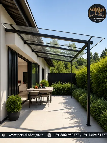 A minimalist glass canopy providing a sheltered outdoor dining space. The simple, elegant design offers protection from the elements without obstructing the view of the surrounding garden.