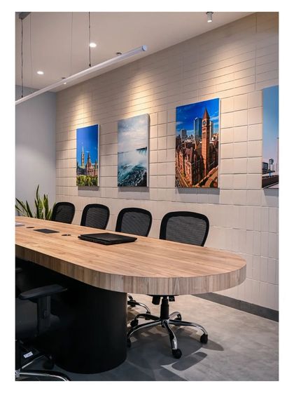A closer view of the conference table and the textured tile wall, which is adorned with photos of the college's campus and Canadian landmarks.