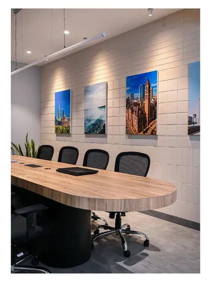 A closer view of the conference table and the textured tile wall, which is adorned with photos of the college's campus and Canadian landmarks.