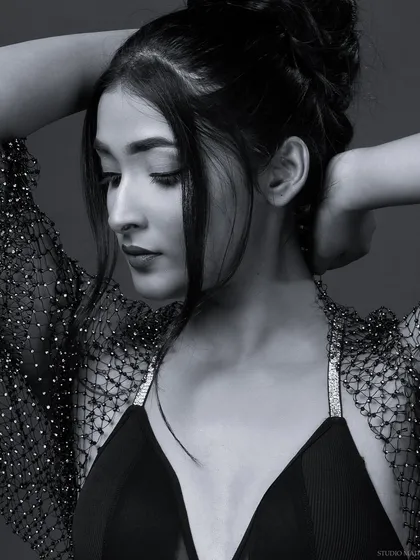 A pensive black and white portrait with an updo hairstyle. The monochrome style brings a quiet, introspective mood to this fashion shot.