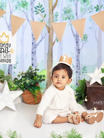 The king of all the wild things, wearing his little crown. The woodland theme with its neutral tones and leafy greens is perfect for a rustic 'Wild One' photoshoot.