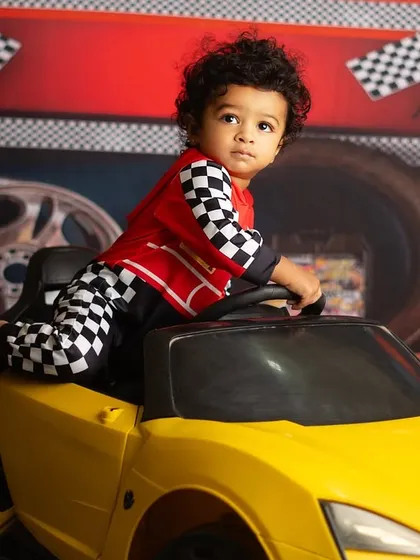Taking the wheel of his very own sports car. Themed shoots for one year olds are all about letting them play and explore.