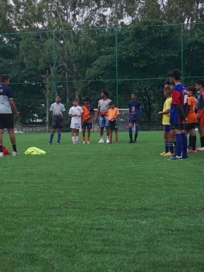 A smaller group of players receives specific instructions from a coach during a break in the trial matches.