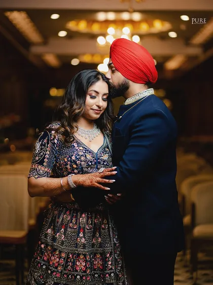 A tender forehead kiss, symbolizing love and commitment. This is a timeless and emotional engagement portrait.