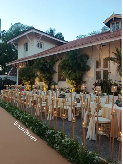 A side view of the candle-lined path, showing how it defines the event space and adds a layer of warmth and sophistication to the outdoor seating area for the Parsi wedding ceremony.