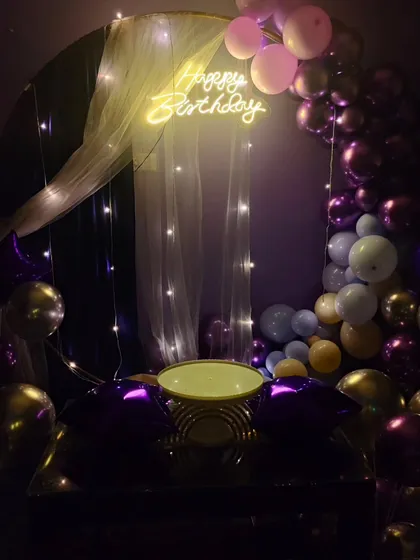 For a softer, more elegant birthday look, I used a sheer curtain with fairy lights behind the neon sign. This design combines a partial balloon arch with a delicate, lit backdrop, perfect for milestone birthdays.