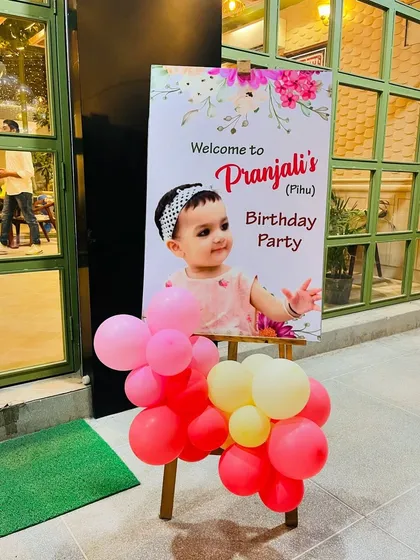 We add personal touches to make every party unique. This custom welcome easel for "Pranjali's Birthday Party" features a photo of the birthday girl and a small balloon cluster, creating a warm and personal greeting for guests.