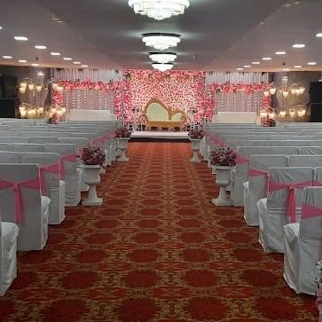 The interior of Grand Celebration banquet in Seawoods, set up for a wedding. The long red carpet and white seating create a classic and formal look.