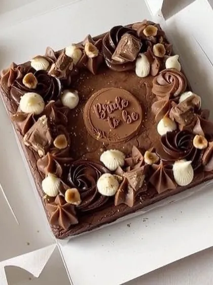 A special brownie slab for a special occasion. This one was customized for a bride-to-be, decorated with rich chocolate swirls, hazelnuts, and a custom chocolate plaque.