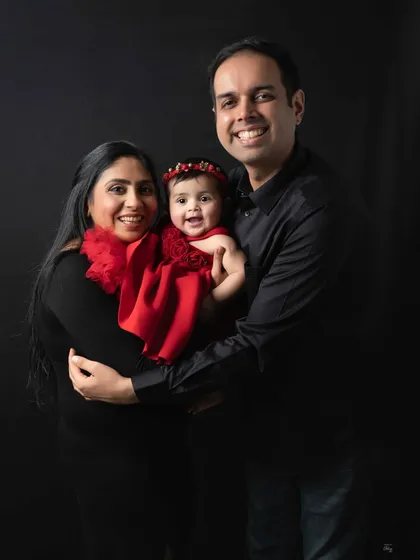 Classic studio portraits are about capturing your family's connection with a touch of elegance. The bold red against the dark backdrop makes this beautiful family's smiles truly pop.