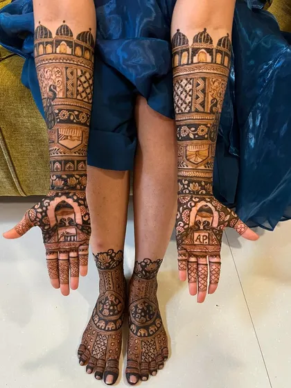 A complete view of the bride's mehendi, with coordinated designs for her hands and feet. The peacock and palace theme is carried throughout.