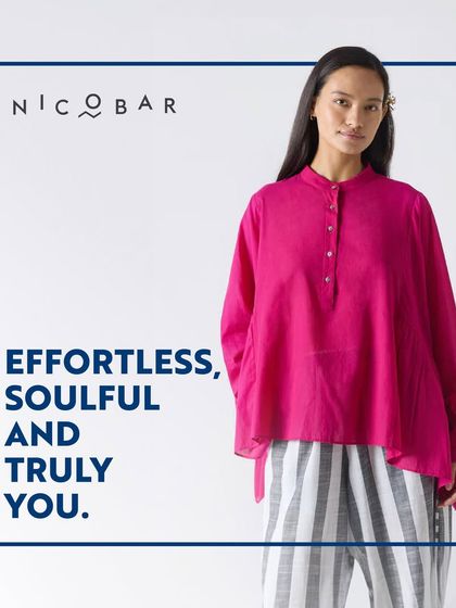 This look from Nicobar, featuring a bright pink top and striped pants, is described as effortless, soulful, and truly you, reflecting the brand's personal approach to style.