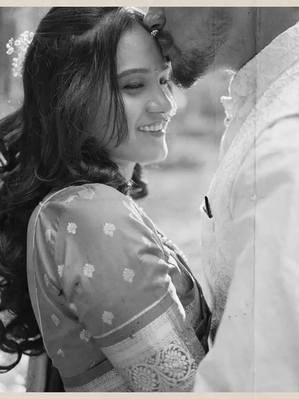 A soft, black and white close-up of a groom gently kissing his bride's forehead. This tender moment is a perfect example of the quiet, heartfelt silences I love to capture.