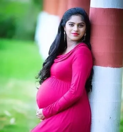 A vibrant portrait of an expectant mother in a beautiful red dress. We can help with location and wardrobe suggestions for your maternity shoot.