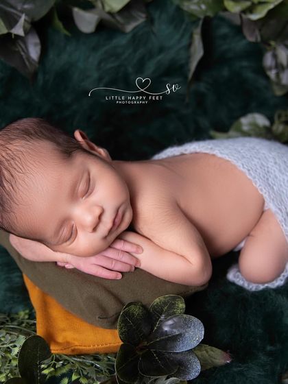 The classic tummy-time pose. Set against a backdrop of simple greenery, this pose is perfect for showing off the baby's sweet face and tiny back rolls.