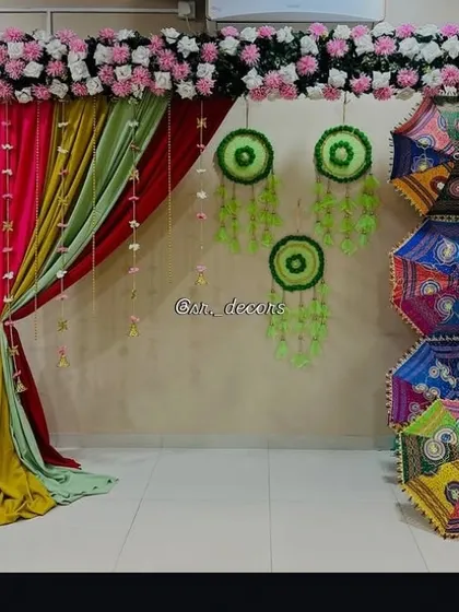 In this Mehndi setup, I used Rajasthani umbrellas as a side accent to complement the colorful drapes and green dreamcatchers, adding a traditional touch to the decor.