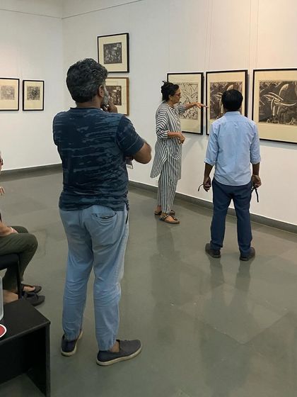The curator and team discussing the placement of a series of woodcut prints.