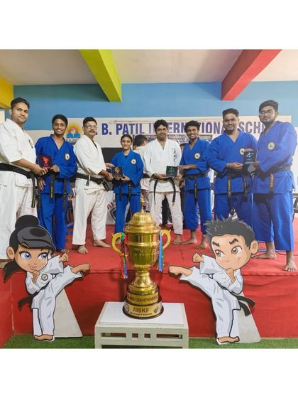 The team managers and instructors stand proudly with the championship trophy for the upcoming AISKF Warriors League. Leadership is a core part of our philosophy.
