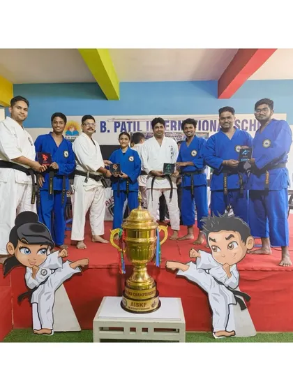The team managers and instructors stand proudly with the championship trophy for the upcoming AISKF Warriors League. Leadership is a core part of our philosophy.
