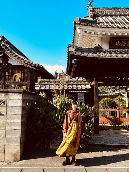 Exploring the streets of Japan, styling a vintage-inspired dress with a longline jacket and chunky boots.