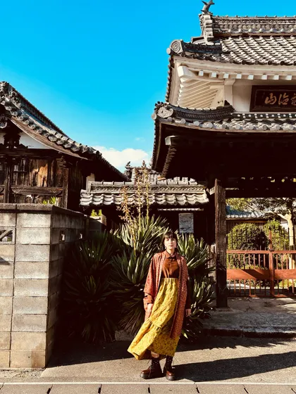 Exploring the streets of Japan, styling a vintage-inspired dress with a longline jacket and chunky boots.