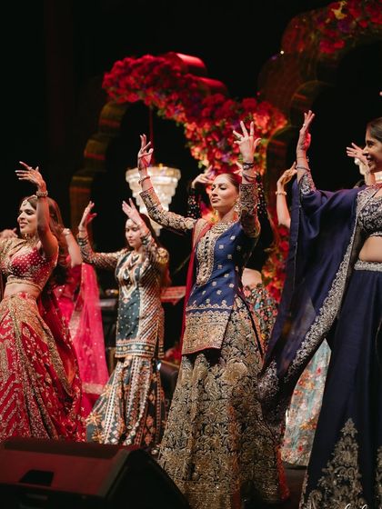 A snapshot of pure joy and energy from a bride and her squad. This moment captures the excitement and fun of a group performance on the sangeet night.