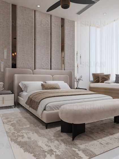 A serene and elegant bedroom design with a tall, upholstered headboard featuring vertical panels and mirrored strips. A cozy window seat provides a perfect spot to relax.