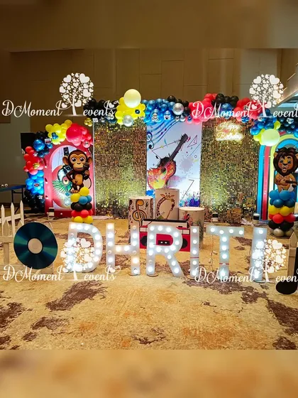 A full view of the musical stage, showing the marquee letters, the backdrop with a guitar graphic, and the fun animal character props.