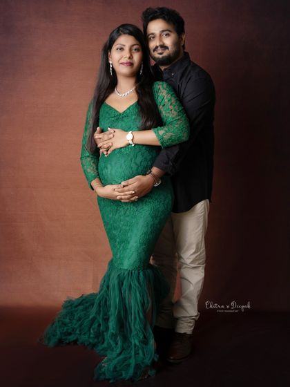 A classic couple's portrait showcasing their love and connection. The partner's hands gently holding the bump is a timeless touch.