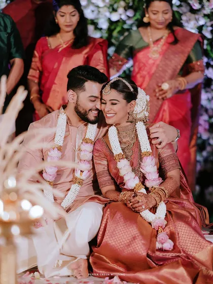 An intimate portrait of the couple seated at their ceremony, their hands clasped, sharing a happy, loving glance.