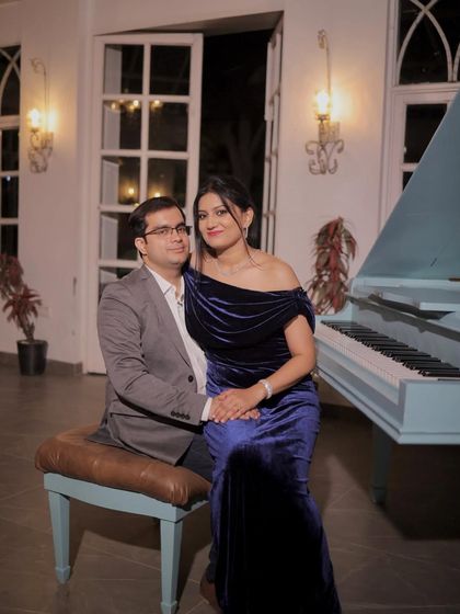 A classic portrait of the couple by the piano. Her makeup is timeless and beautiful, perfect for this romantic setting.