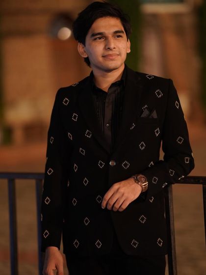 A few shots from a photoshoot for a men's ethnic wear brand, showcasing a sharp, all-black reception look.