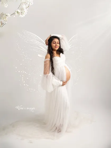 Let's bring your fairytale to life. Whether you dream of being an angel or a character from a fantasy story, I use creative props like these delicate wings and ethereal lighting to craft truly magical and whimsical pregnancy portraits.