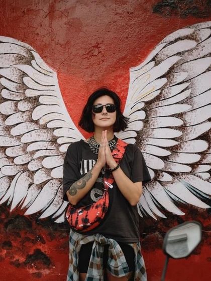 The custom Selena Artichoke Red styled against a backdrop of angel wings, perfectly capturing its artistic and rebellious vibe.