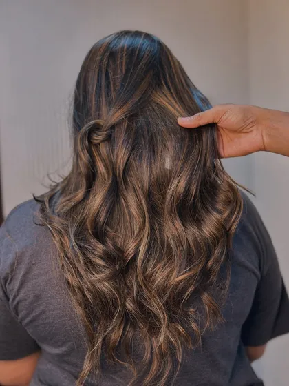 A close up on the revived warm tones. This balayage is perfect for adding richness and depth to brunette hair.