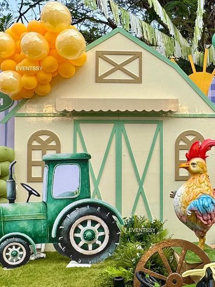 A large tractor cutout and a rooster prop stand in front of the custom-built barn backdrop.