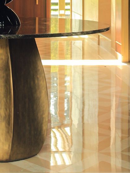 The finished product: a stunning table base crafted from bent brass sheets, now installed in the Vasant Kunj farmhouse. This shows the beautiful result of our detailed fabrication process.