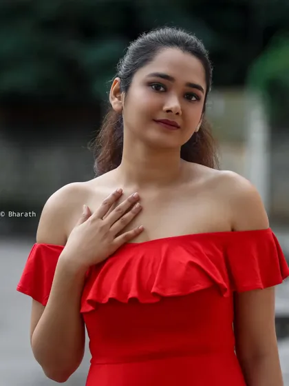 A classic portrait of the model in the red dress, with a soft smile. This image is perfect for a portfolio, showcasing a friendly and approachable look.