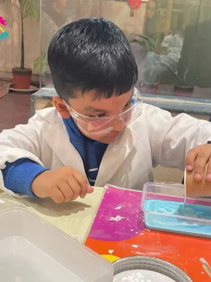 A young boy carefully pours liquid for his experiment, demonstrating the focus and precision that these activities can foster.